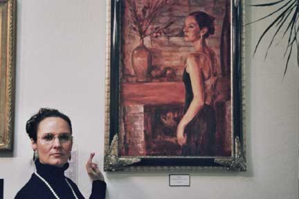 Artist, Riki Nelson, with one of her paintings